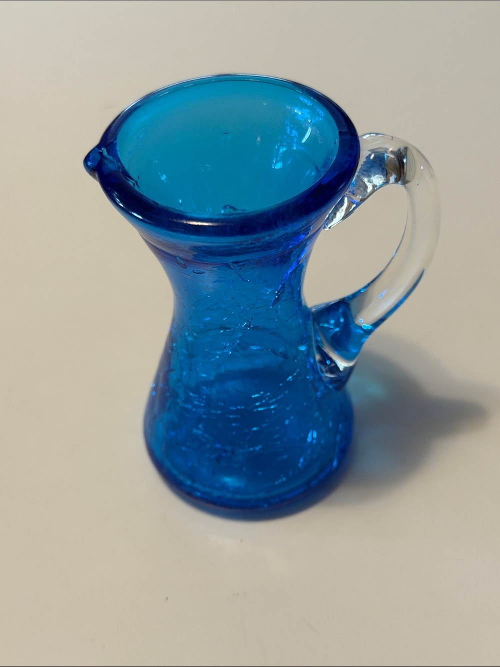 Mid Century Modern blue crackle glass pitcher. Good condition. Clear handle.